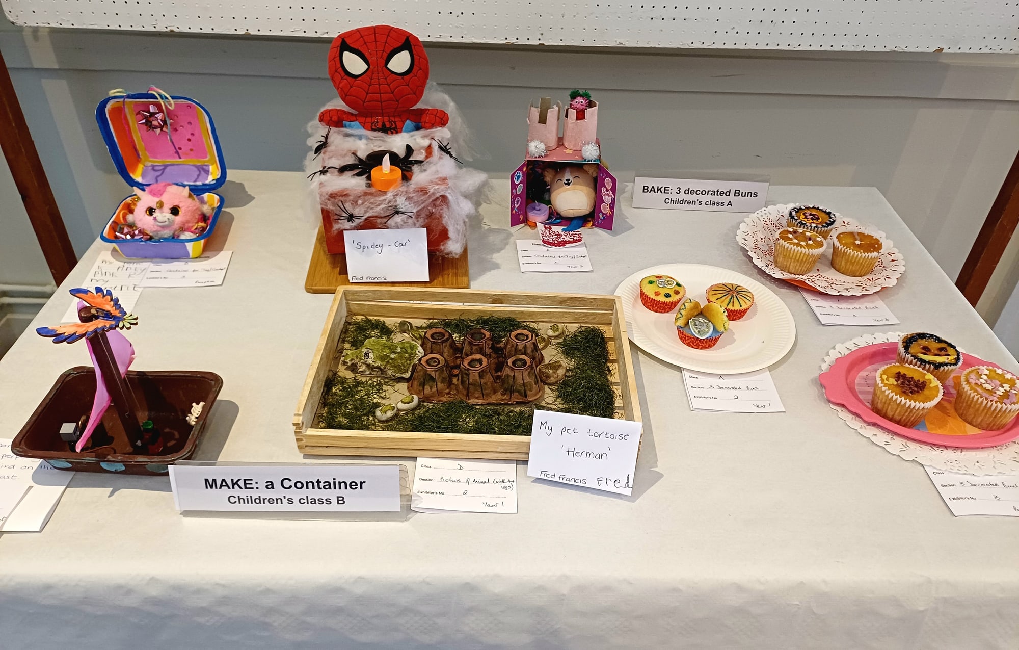 Children's handmade containers, animal models, and decorated buns displayed at the Summer Show